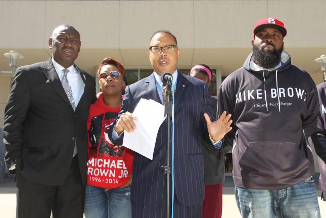 Family attorney Anthony Gray announces that the parents of Michael Brown have filed a civil lawsuit in the Aug. 9 shooting death of their son Michael by Ferguson Police Officer Darren Wilson, as attorney Benjamin Crump, mother Lesley McSpadden and father Michael Brown Sr. stand by outside the St. Louis County Courts building in Clayton, Mo. The suit seeks ,000 in damages, in addition to attorney fees. Photo by Bill Greenblatt/UPI | License Photo