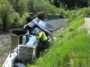 A tractor-trailer hauling 13 tons of Fat Boy Ice Cream Sandwiches lands upside down in the Logan River - Photo: Utah Highway Patrol