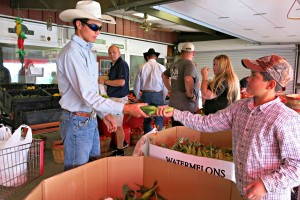 Coalville brothers Coltere (right) and Daniel Shulz choose earns of corn while their dad, Zeph, checks out the tomatoes. Photo: Gephardt Daily/Nancy Van Valkenburg