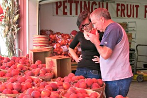 Customers check a peach's scent, a good indicator of the fruit's ripeness and flavor intensity. Photo: Gephardt Daily/Nancy Van Valkenburg