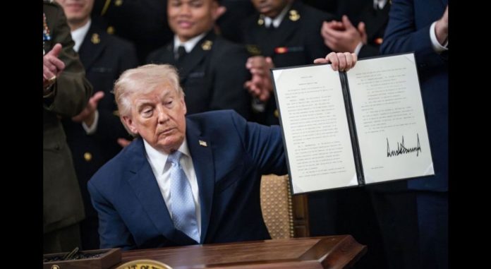 President Donald Trump holds a signed executive order instructing the Federal Communications Commission and Secretary of Commerce to ensure the Army-Navy football game has an exclusive broadcast window during the Commander in Chief's Trophy to the Navy Midshipmen football team in the East Room of the White House on Friday. Photo by Bonnie Cash/UPI