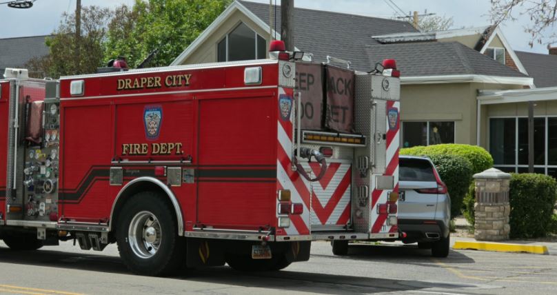 Red Draper City Fire Department fire truck parked on a street near houses, rear and side compartments visible.
