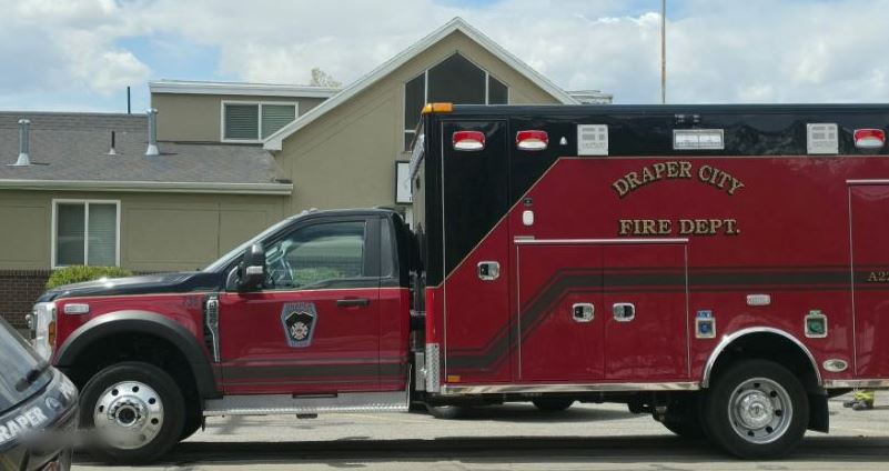 Red Draper City Fire Department rescue truck parked on a residential street with beige buildings in the background.