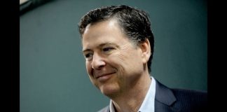 Smiling man in a dark blazer and light shirt, looking slightly to the right (profile portrait).”,