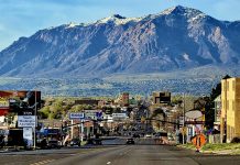 Anago Commercial Cleaning of Utah expands to meet rising demand in Davis, Weber counties Wide city street with cars and billboards, mountains in the distance under a blue sky.