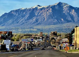Anago Commercial Cleaning of Utah expands to meet rising demand in Davis, Weber counties Wide city street with cars and billboards, mountains in the distance under a blue sky.