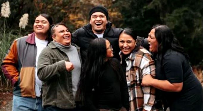 Group of six diverse friends outdoors in autumn, smiling and laughing together.