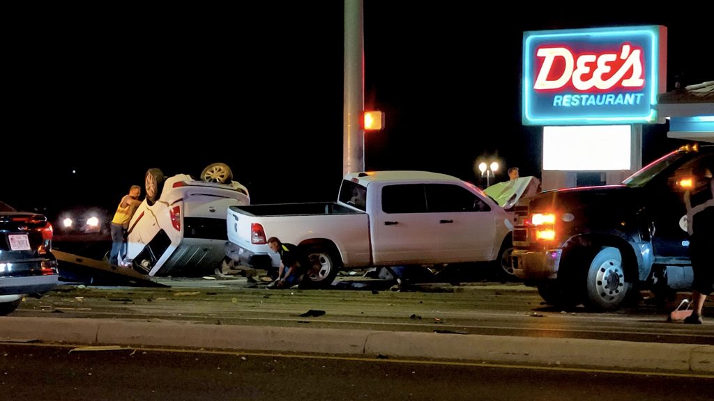 WhatsApp Image 2026-05-25 at 004657 2 | Gephardt Daily Nighttime car crash: a white pickup and an overturned SUV with responders assessing debris under a neon sign.