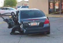 1 dead, 2 injured in Roy crash Blue Honda Accord with extensive driver-side damage after a crash; driver's door open and debris on pavement with caution tape in background of a storefront lot.