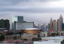 Las Vegas skyline featuring the Park MGM and nearby arena with surrounding hotels and high rises under a cloudy sky.