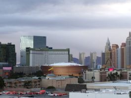 Las Vegas skyline featuring the Park MGM and nearby arena with surrounding hotels and high rises under a cloudy sky.