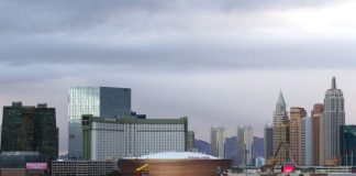 Las Vegas skyline featuring the Park MGM and nearby arena with surrounding hotels and high rises under a cloudy sky.