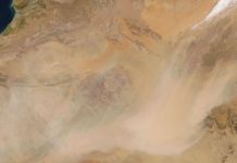 49 people dead in Sahara Desert after truck breaks down Aerial view of a sandy desert with a broad dust cloud sweeping across the landscape