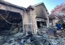 Resident and cat safe, garage and RV total losses in Herriman fire Charred, partially collapsed house with debris in the yard and a firefighter near the garage.