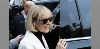 Stylish woman with short blond hair and black sunglasses stepping from a black car, paparazzi in the background.