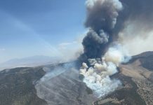 UPDATE: Wildfire evacuations underway for ranches north of Eureka; others near Iron Fire on ‘ready’ status Tall smoke plume rising from a wildfire on a hillside in a mountainous area, with scorched terrain nearby.