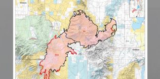 Topographic map with a large pink-outlined region and red boundary lines in the center.