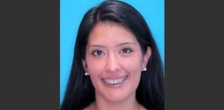 Portrait of a smiling woman with long dark hair, braces, and pearl earrings against a bright blue background.