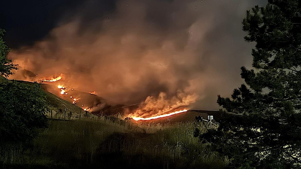 Bonneville Fire Salt Lake City | Gephardt Daily Nighttime brush fire sweeping across a hillside flames and thick smoke rising behind trees