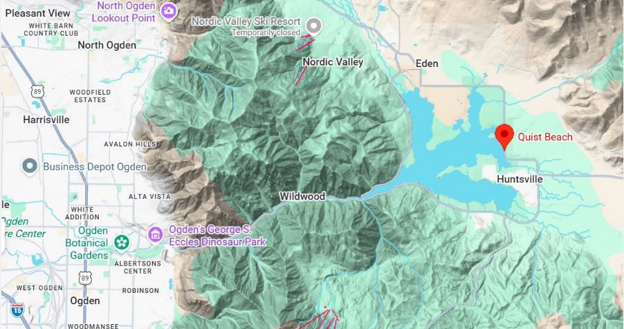 Topographic map showing a red pin at Quist Beach on a lake east of Huntsville, Utah, with Ogden to the west and nearby towns.
