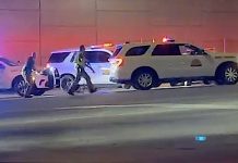 VIDEO: UHP troopers nab driver clocked on I-15 at 106 mph in Draper Nighttime emergency scene with police car flashing blue lights, a white SUV, and responders near a pink-lit wall on a street.
