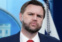 U.S.-Iran talks abruptly postponed Bearded man in a dark suit and red tie with a serious expression against a blue backdrop.