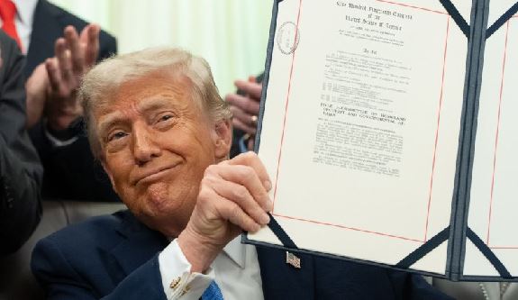 Trump-signs-70B-bill-to-fund-Homeland-Security-Dept-through-2028 Donald Trump holding a framed certificate, smiling at the camera.