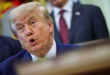 Trump threatens to ‘take’ Kharg Island, Iran’s main oil hub Close-up of a man with light hair in a dark suit and yellow tie speaking, with a blurred background.