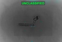 Infrared surveillance image showing a small elongated vessel with a plume, labeled UNCLASSIFIED in bright green at the top.