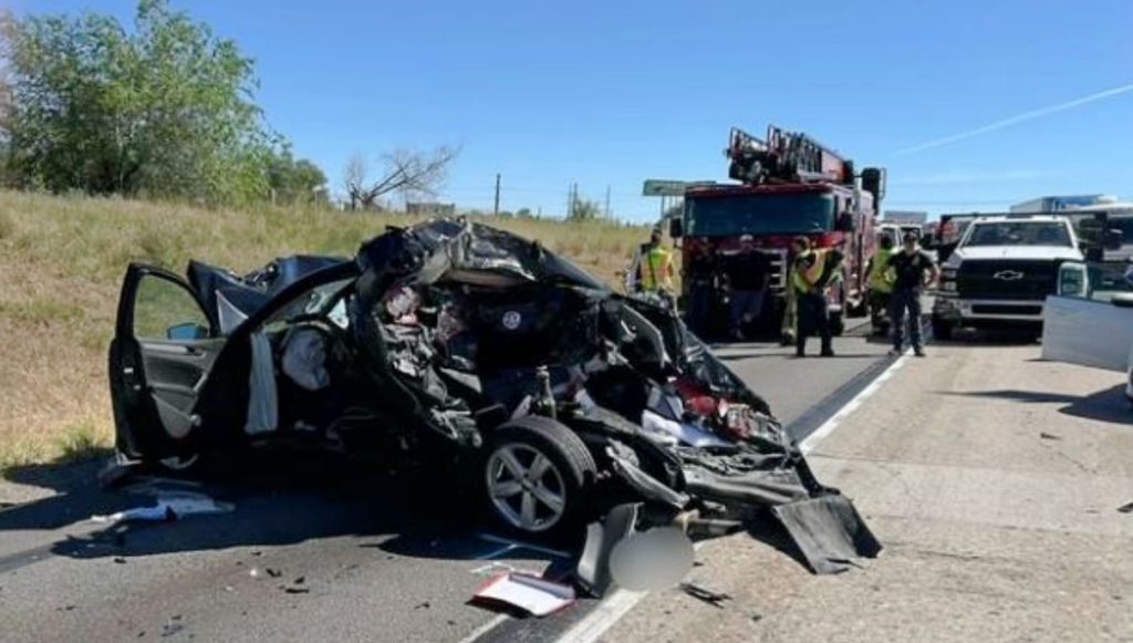 Uhp1 | Gephardt Daily Crushed car with its front end destroyed on a highway; firefighters and a fire truck are on scene behind it