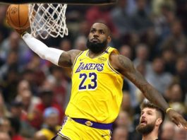 LeBron James of the Los Angeles Lakers wearing #23 dunks toward the hoop during a crowded game.