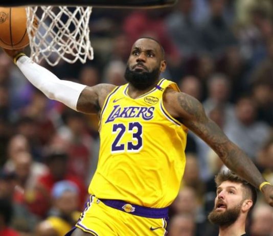 LeBron James of the Los Angeles Lakers wearing #23 dunks toward the hoop during a crowded game.