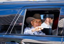 Church pres. Dallin H. Oaks appears in Days of ’47 parade Elderly man wearing a brown cowboy hat and glasses waves from the window of a blue car.