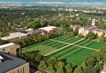 Aerial view of a university campus quad with striped green lawns, intersecting paths, and surrounding trees and buildings.